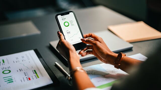 Oma talous - Woman hand holding phone in office landscape - small